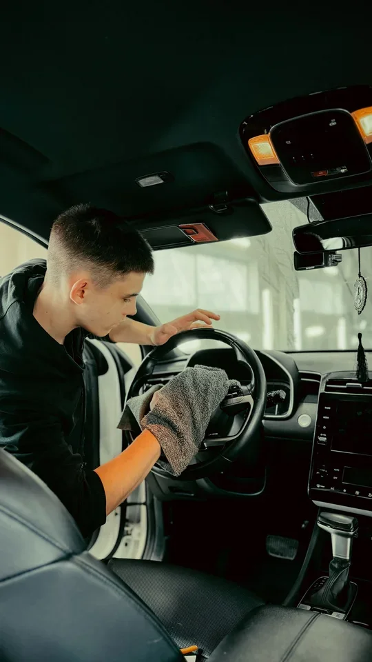 Limpeza do volante de um carro com pano. Imagem ilustrativa; não representa unidade, equipe ou produto da marca.