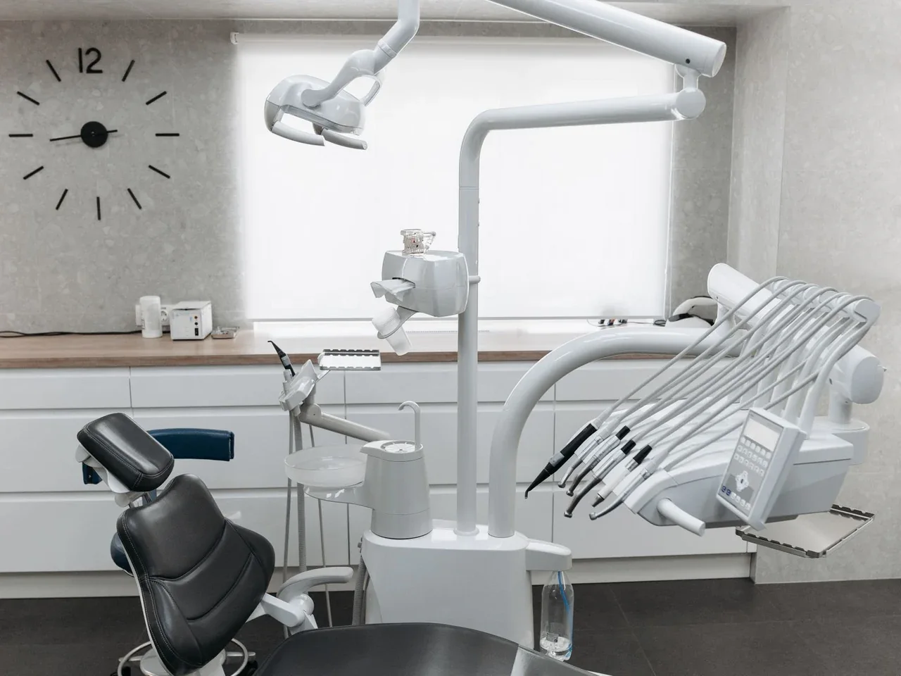 Cadeira odontológica com refletor e equipamentos. Imagem ilustrativa.